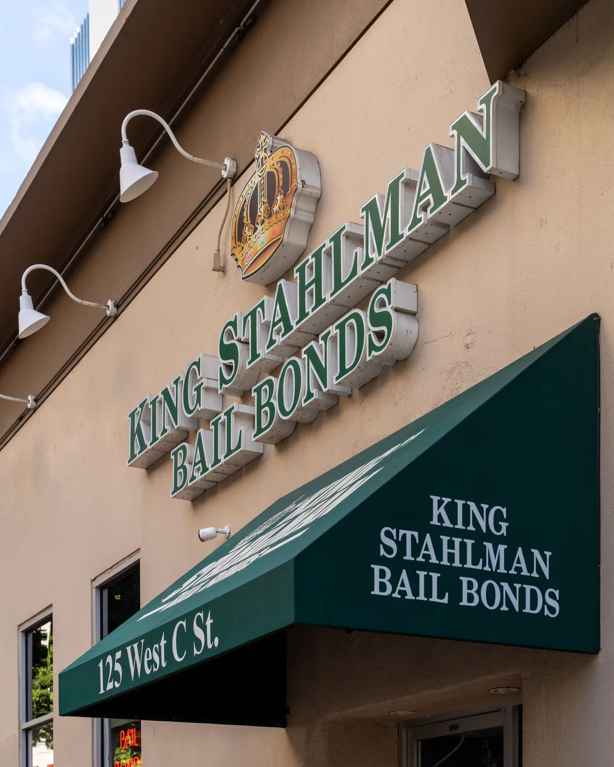 The King Stahlman® Bail Bonds storefront at 125 West C St. in downtown San Diego, showing the green awning and illuminated crown sign